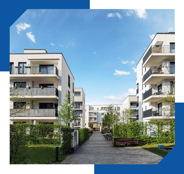 Modern white apartment buildings with balconies along a landscaped walkway