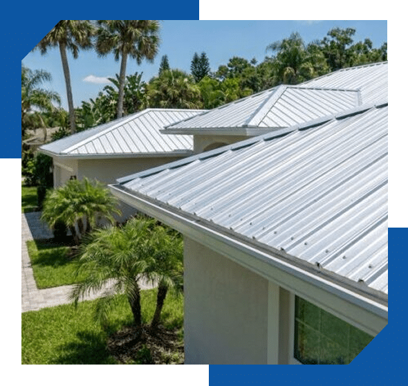 Close-up of silver standing-seam metal roof panels and eaves on a home with palm trees