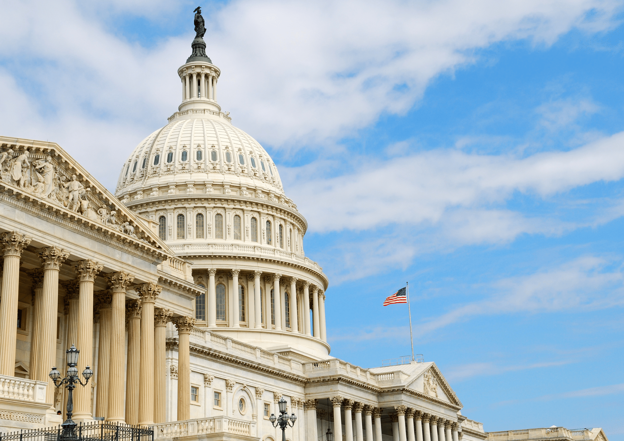 U.S. Capitol dome and columns under a blue sky, representing government buildings