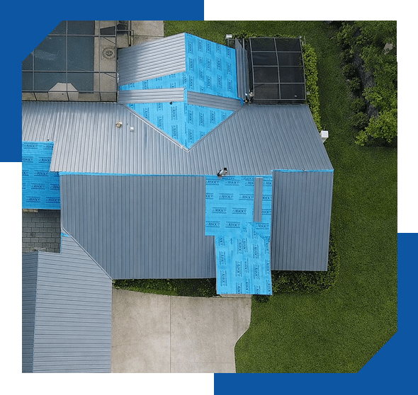 Aerial view of a home getting a new standing seam metal roof over blue synthetic underlayment