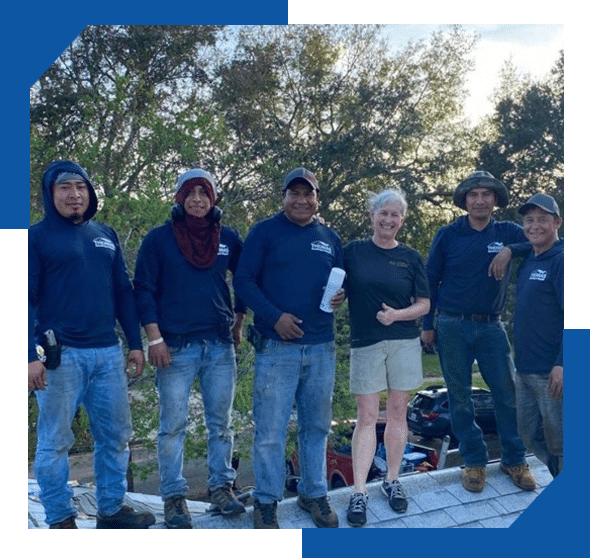 Thomas Roofing crew in company shirts standing on a roof with a smiling homeowner