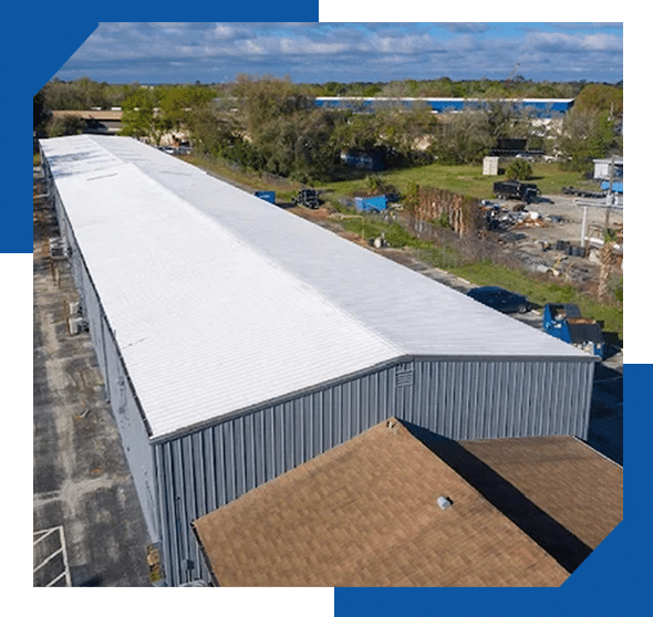 Aerial view of a long commercial metal building with a freshly coated white roof