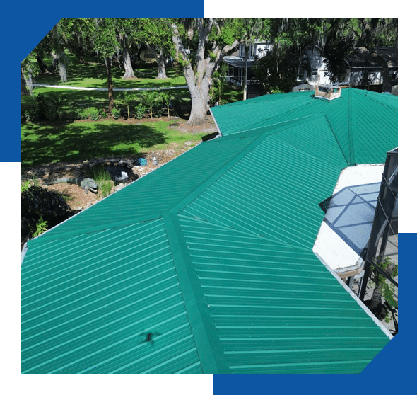 Green standing seam metal roof on a home surrounded by large oak trees