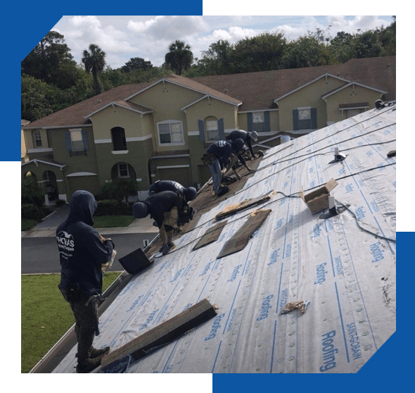 Roofing crew installing new shingles over synthetic underlayment on a townhome building roof