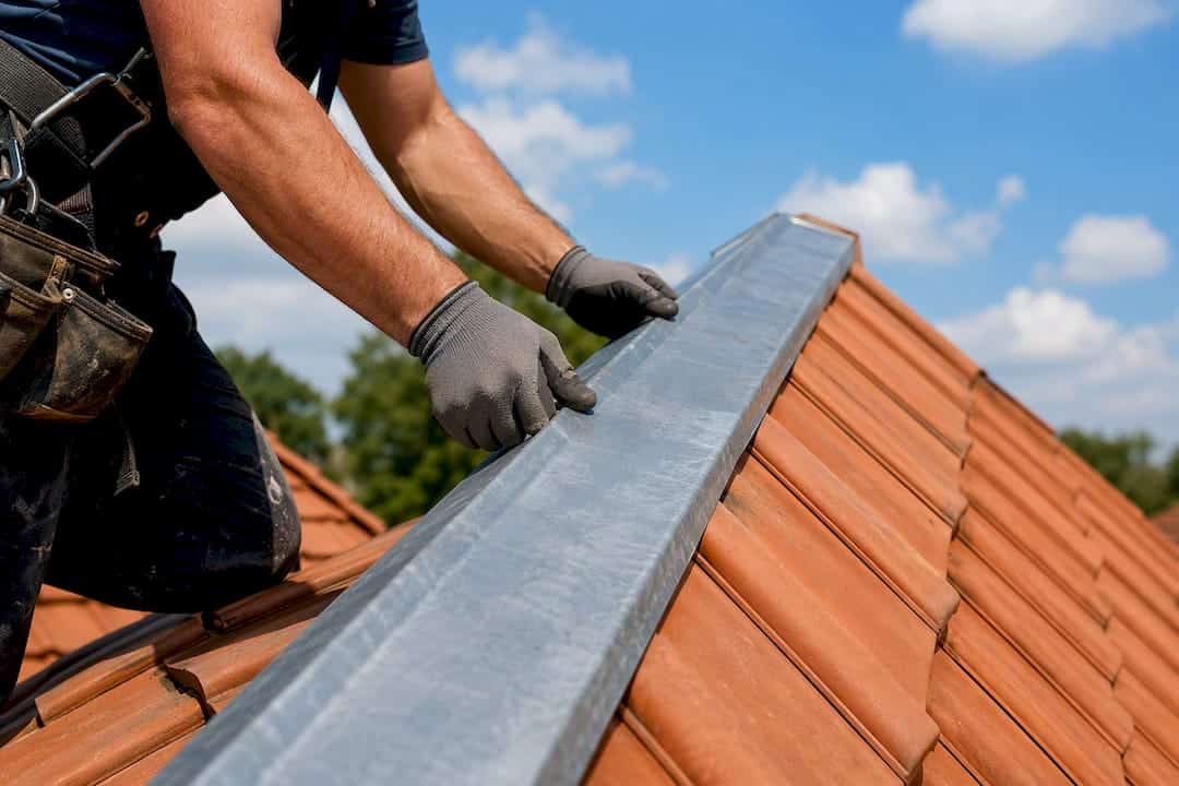 Zinc ridge strip being installed on roof peak