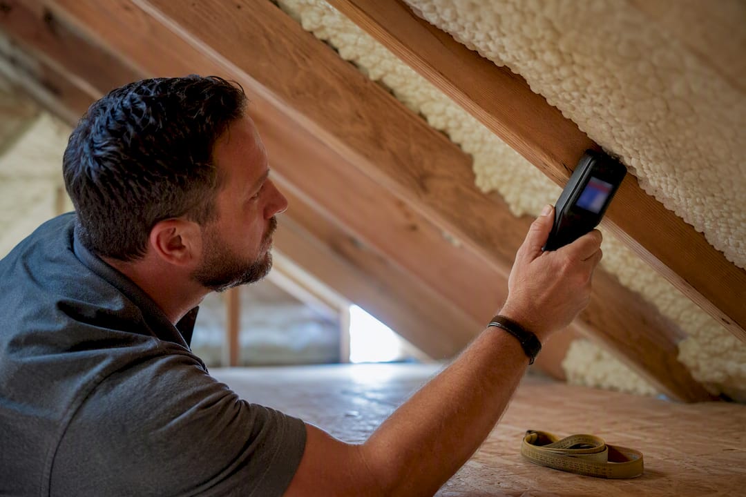 Inspector checking moisture near spray foam